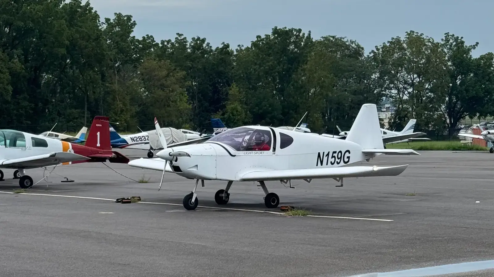 N159G parked on the ramp alongside other small airplanes